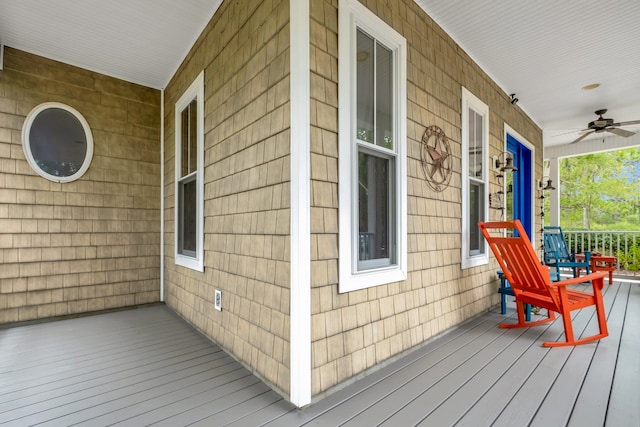 wooden deck with a porch and ceiling fan