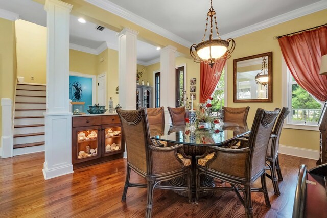 dining area featuring hardwood / wood-style floors, decorative columns, and ornamental molding