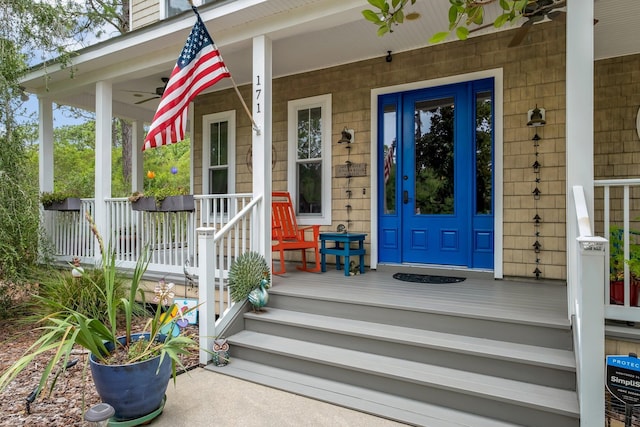 entrance to property featuring covered porch and ceiling fan