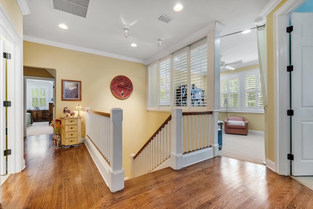 hall with ornamental molding, a wealth of natural light, and light hardwood / wood-style floors