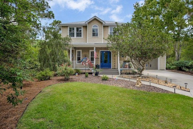 view of front of home featuring a garage, covered porch, and a front yard