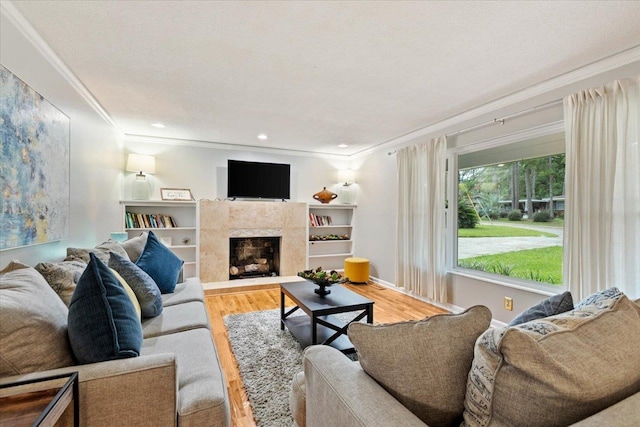 living room with crown molding, light hardwood / wood-style flooring, a premium fireplace, and a textured ceiling