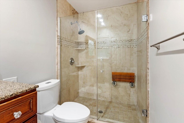 bathroom with vanity, a shower with shower door, and toilet