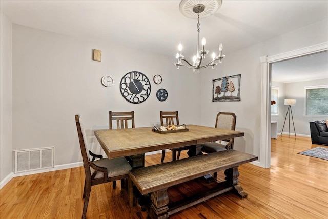 dining room featuring light hardwood / wood-style flooring and a notable chandelier