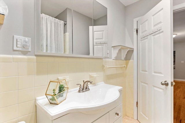 bathroom with vanity, wood-type flooring, and tile walls