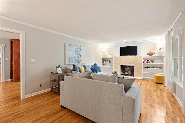 living room with light wood-type flooring and ornamental molding