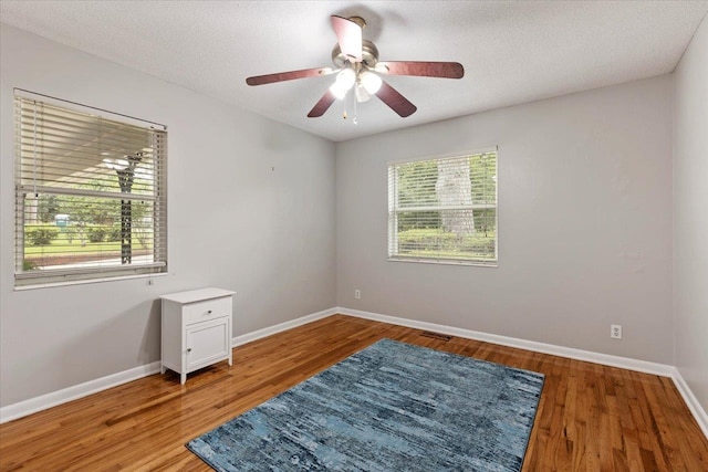 unfurnished room featuring hardwood / wood-style floors, a textured ceiling, and ceiling fan