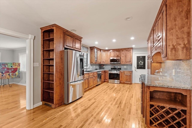 kitchen with backsplash, stainless steel appliances, light hardwood / wood-style floors, and sink