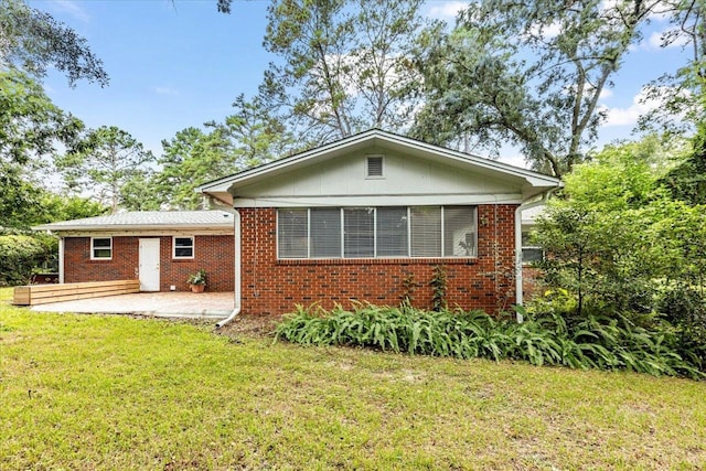 back of house with a lawn and a patio area