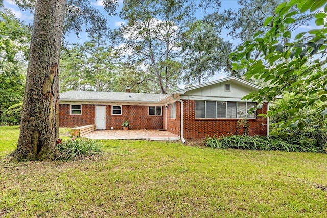 rear view of house with a yard and a patio area