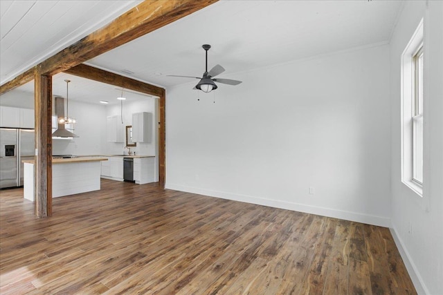 209 SE 10th St, Steinhatchee, FL 32359 - unfurnished living room featuring a ceiling fan, dark wood finished floors, baseboards, a sink, and beamed ceiling
