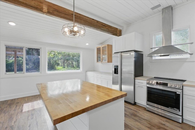 209 SE 10th St, Steinhatchee, FL 32359 - kitchen featuring appliances with stainless steel finishes, wall chimney exhaust hood, butcher block counters, white cabinetry, and a chandelier