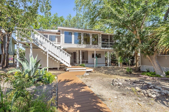 35 Sunrise Ln, Panacea, FL 32346 - rear view of house with stairway, a sunroom, and a deck