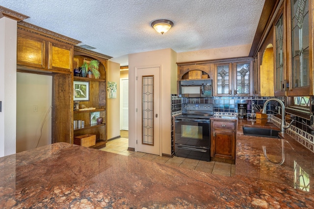 35 Sunrise Ln, Panacea, FL 32346 - kitchen featuring black appliances, a sink, light tile patterned floors, tasteful backsplash, and glass insert cabinets