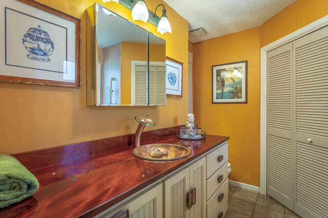 35 Sunrise Ln, Panacea, FL 32346 - bathroom with vanity, tile patterned floors, a closet, and a textured ceiling