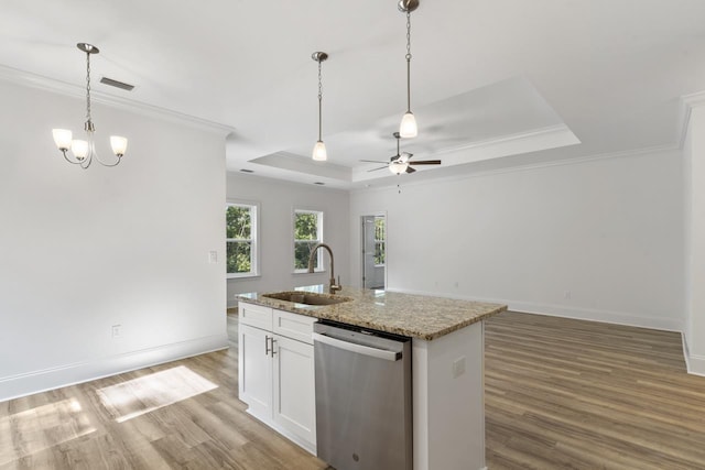 kitchen featuring a tray ceiling, white cabinetry, a sink, an island with sink, and dishwasher