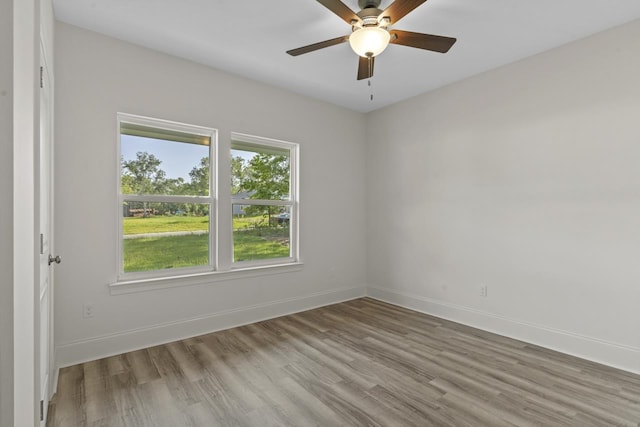 empty room with light wood-type flooring, ceiling fan, and baseboards