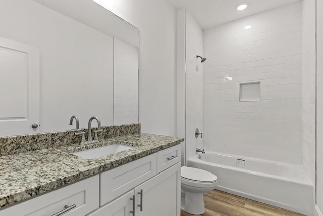 full bathroom with shower / washtub combination, recessed lighting, toilet, vanity, and wood finished floors