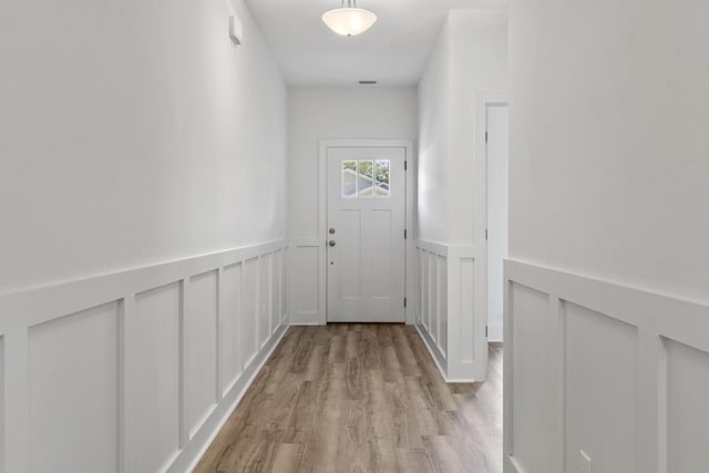 entryway featuring light wood-style floors, visible vents, and wainscoting