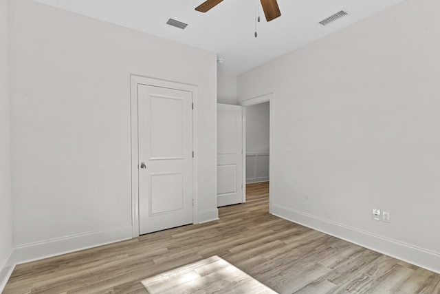 empty room featuring baseboards, visible vents, ceiling fan, and light wood finished floors