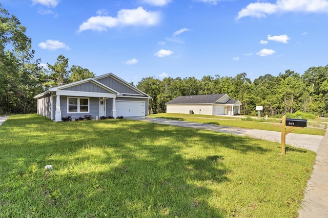 view of front of house with board and batten siding, a front yard, driveway, and a garage