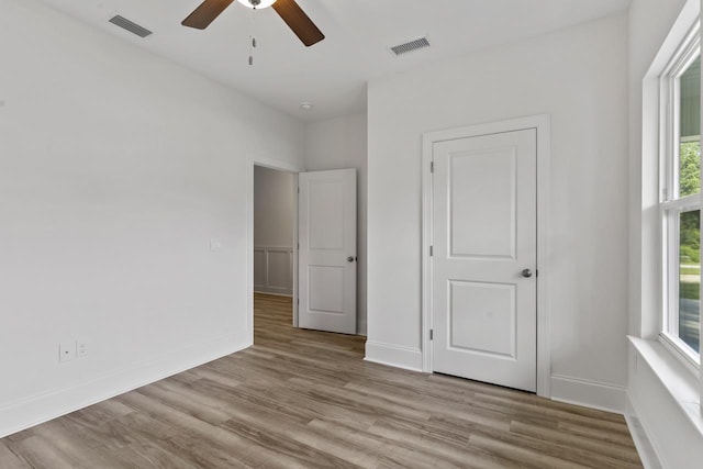 unfurnished bedroom with light wood-style floors, visible vents, and baseboards