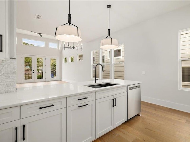 kitchen with dishwasher, decorative light fixtures, white cabinets, and sink