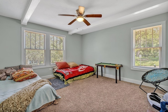 carpeted bedroom featuring beamed ceiling and ceiling fan