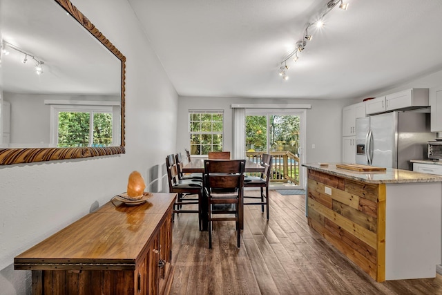 dining space with a healthy amount of sunlight and dark hardwood / wood-style floors