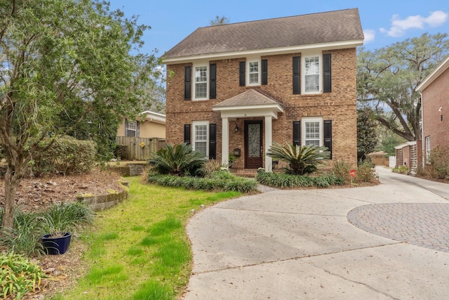 colonial-style house featuring a front lawn