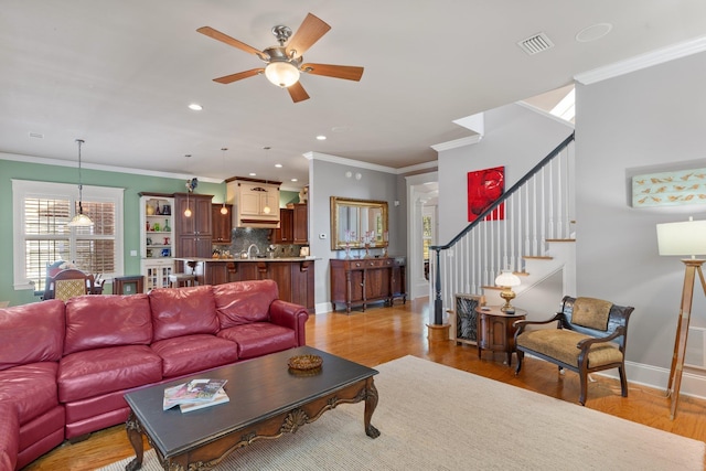 living room with crown molding, sink, ceiling fan, and light hardwood / wood-style flooring