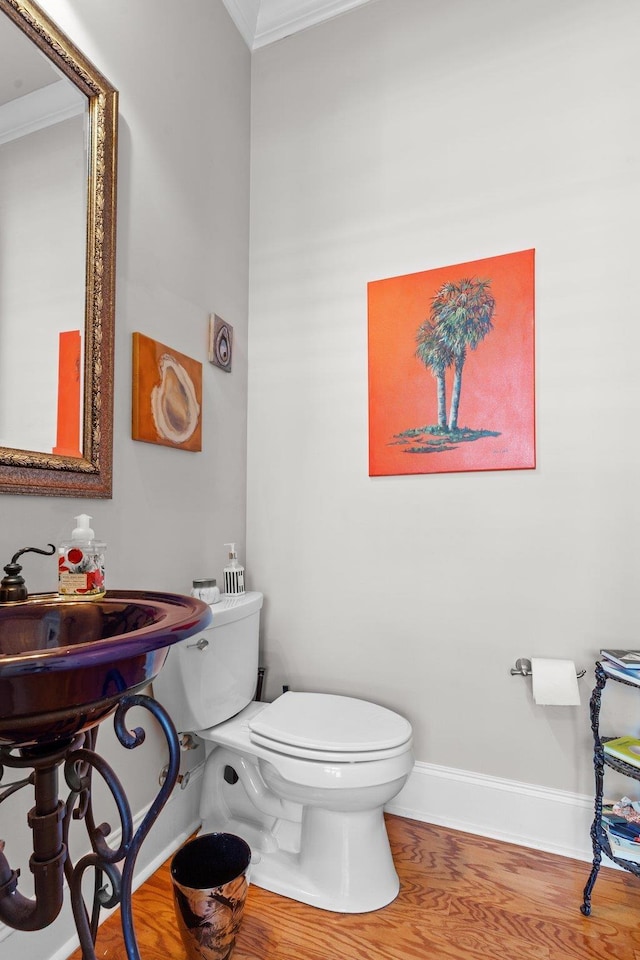 bathroom featuring crown molding, wood-type flooring, and toilet