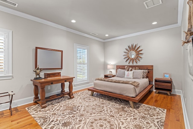 bedroom with crown molding and hardwood / wood-style floors