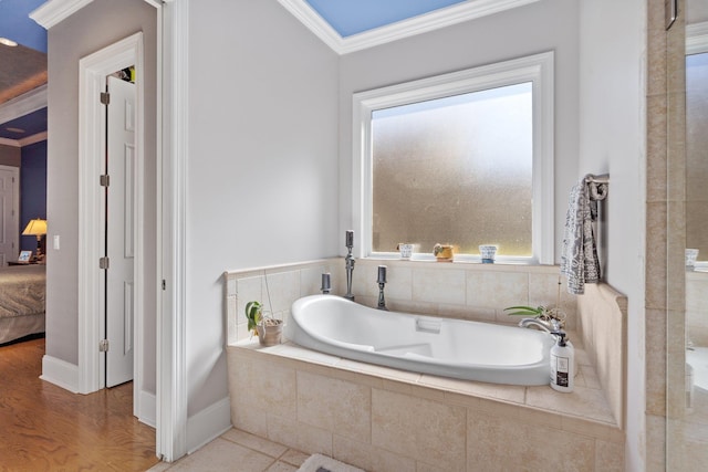 bathroom with crown molding, a relaxing tiled tub, and hardwood / wood-style floors