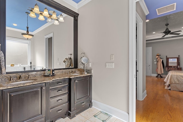 bathroom with vanity, wood-type flooring, ornamental molding, and ceiling fan