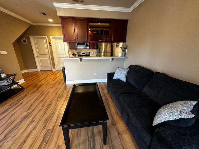 living room with crown molding and light hardwood / wood-style floors