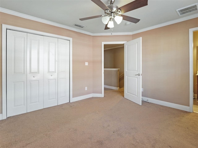 unfurnished bedroom with ornamental molding, light colored carpet, a closet, and ceiling fan