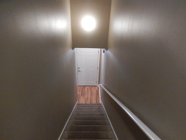 staircase with hardwood / wood-style flooring