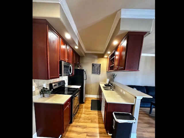 kitchen featuring sink, crown molding, tasteful backsplash, light hardwood / wood-style flooring, and appliances with stainless steel finishes