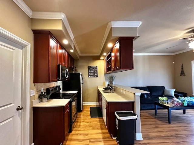 kitchen featuring a breakfast bar, sink, decorative backsplash, black electric range, and light hardwood / wood-style flooring