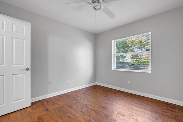 empty room featuring ceiling fan, baseboards, and wood finished floors