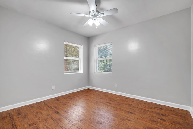 empty room featuring wood finished floors, a ceiling fan, and baseboards