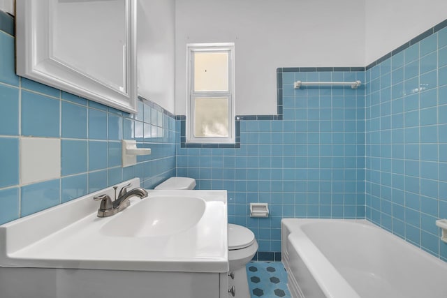 bathroom with wainscoting, tile walls, toilet, and vanity