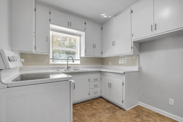 kitchen with tasteful backsplash, baseboards, range, light countertops, and a sink