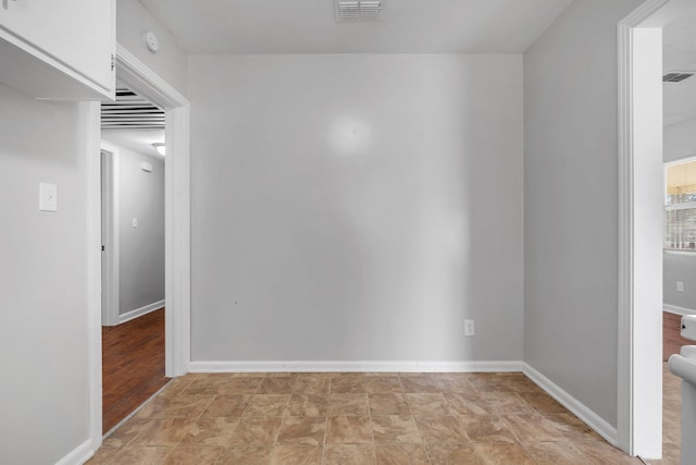 empty room with baseboards and visible vents