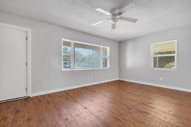 empty room featuring a healthy amount of sunlight, baseboards, and wood finished floors