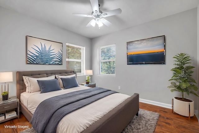 bedroom with ceiling fan, baseboards, and wood finished floors