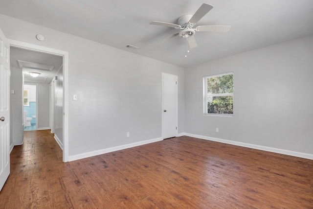 unfurnished room with a ceiling fan, visible vents, baseboards, and wood finished floors