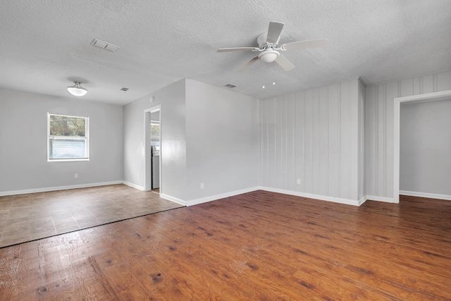 spare room featuring baseboards, visible vents, ceiling fan, and hardwood / wood-style floors