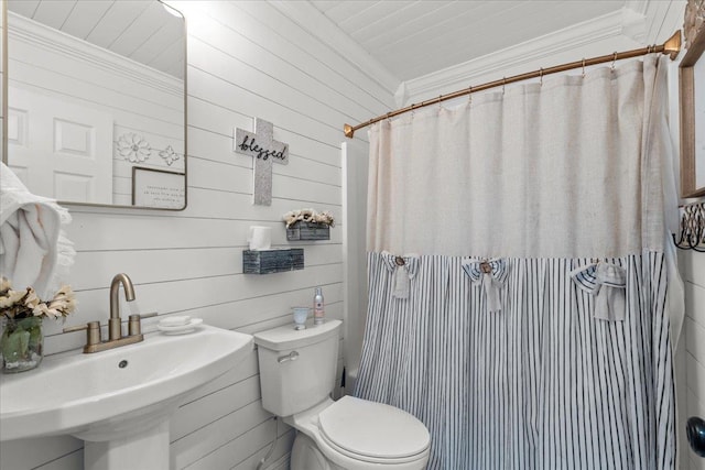 bathroom featuring ornamental molding, wood walls, sink, and toilet